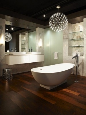 Eine Lampe aus vielen kleinen LEDs hängt über einer Badewanne. Die Decke ist dunkel gestrichen, der Fußboden mit dunkem Holz versehen.
