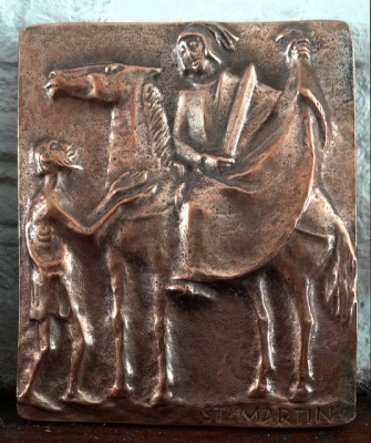 Ein Bronzetafel zeigt den heilen Martin, wie er seinen Mantel für einen Bettler teilt.