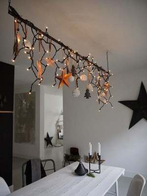Um eine Stange über dem Esstisch wurde eine Lichterkette sowie weihnachtliche Deko-Elemente gewickelt und gehangen. 