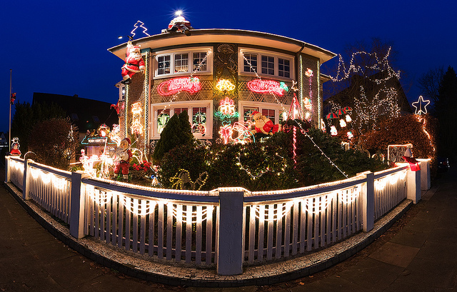 Ein Garten ist über und über mit Weihnachtsbeleuchtung geschmückt. Viele lustige Figuren, dazu Lichterketten und bunte Leuchtbilder.