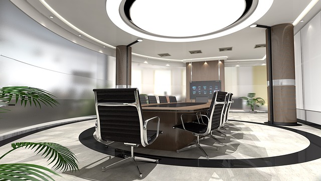 Ein moderner, runder Besprechungsraum wird von einer großen runden Deckenleuchte bzw. Bürolampe sowie von vielen kleineren Strahlern beleuchtet