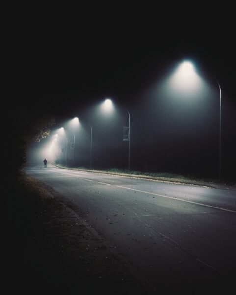Eine dunkle Straße beleuchtet von hellen Straßenlaternen