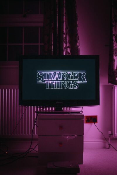 Ein Fernseher mit dem Stranger Things Logo. Die TV Hintergrundbeleuchtung ist rosa.