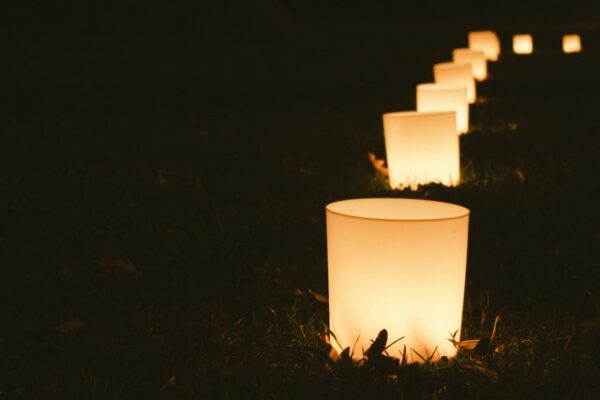 Eine Reihe von elektrischen Kerzen leuchtet im Dunkeln.