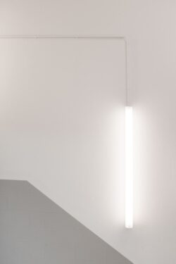 An einer weißen Decke hängt eine schmale LED-Röhre