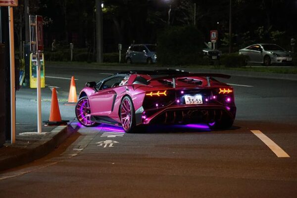 Ein lila Sportwagen wird durch zusätzliche Lichtquellen von unten beleuchtet